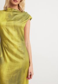 Sleeveless, draped dress in vibrant yellow-green fabric with a smooth texture, featuring a cowl neckline and side-seam detail.