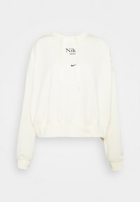 Cream-colored cropped sweatshirt made of soft fabric featuring a drawstring hood and printed Nike logo in black on the front.