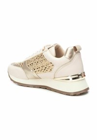 Zapatillas con un esquema de color crema y dorado, que presentan un panel lateral de punto texturizado, detalles metálicos y una suela acolchada para mayor comodidad.