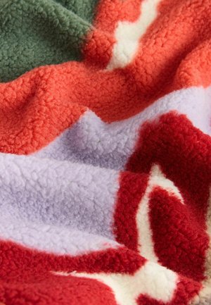 Fleece tæppe med et bølget mønster i farverne rød, orange, grøn, lavendel og creme; tekstureret, blødt og hyggeligt udseende.