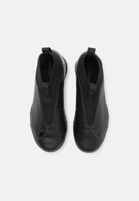 Svart slip-on skor med en elegant design, med en texturerad överdel, elastiska öppningar och en kontrasterande blå accent. Lätta och strömlinjeformade.