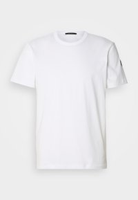 White cotton t-shirt with a round neck and short sleeves; features a subtle logo on the left sleeve. Smooth texture and regular fit.