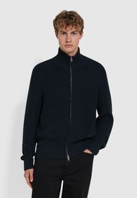 Granatowy sweter z dzianiny w prążki, z zamkiem błyskawicznym i wysokim kołnierzem, z teksturowanej tkaniny i luźnym krojem.