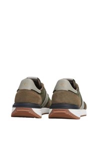 Tamnozeleni i smeđi tenisice od antilopa i mrežaste tkanine; imaju bijelu petu, zlatne akcentne detalje i utisnuti znak na peti.