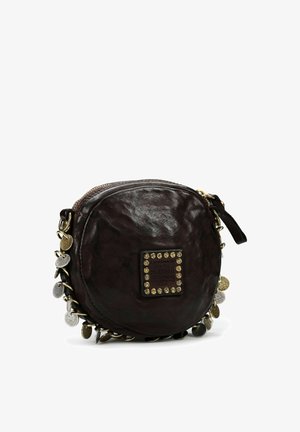 Bolso redondo de cuero marrón con acabado texturizado, herrajes en tono dorado, adornos decorativos de metal a lo largo del borde y una placa rectangular con el logo.