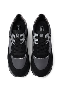 Un paio di sneaker nero e grigio con lacci, con dettagli argentati, viste dall'alto su uno sfondo bianco.