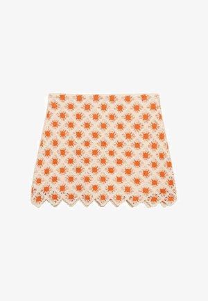 Weißer Stoffrock mit einem durchgängigen Muster aus orangefarbenen Sonnenstrahlen. Der gewellte Saum fügt dem Design eine besondere Note hinzu.