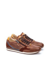 Scarpe atletiche marroni con una tomaia in pelle texturizzata, dettagli in suede, lacci tondi e una striscia blu. Presentano una chiusura con zip sul lato.