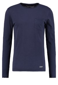 Long-sleeve navy blue T-shirt made of cotton, featuring a round neckline, chest pocket, and subtle brand lettering at the hem.