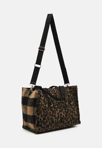 Torba typu tote w wzór panterki, z boku czarno-beżowym w kratę, z nylonowym paskiem na ramię i akcentami w kolorze złotym.