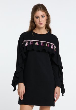 Zwarte sweatshirt jurk met gerafelde mouwen en een decoratieve band met multi-kleurige franjes. Zachte textuur, casual ontwerp, lange mouwen.