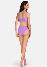 Fioletowy, żeberkowany zestaw bikini z topem na szerokich ramiączkach i high-waisted dołem, podkreślający teksturowany materiał i bezszwowe wykończenia.