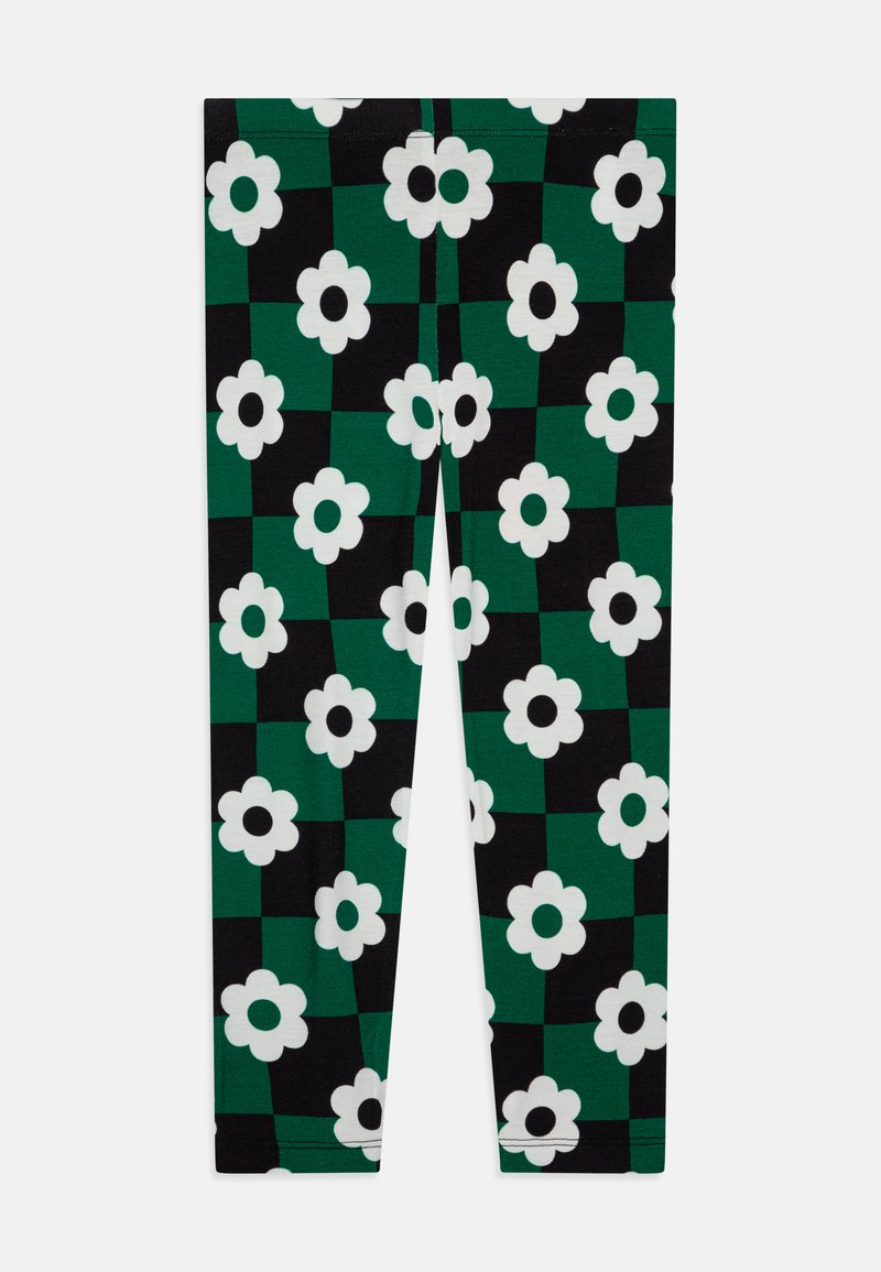 Leggings con un patrón a cuadros en verde y negro, adornados con grandes flores blancas. Están confeccionados con una tela elástica de textura suave.