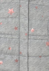 Šedá péřová bunda s prošívaným designem, s metalickými růžovými zlatými hvězdami rozptýlenými po látce. Měkká textura. Viditelné zapínání na zip.