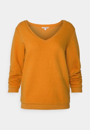Oranje pullover met een V-hals, lange mouwen en een getextureerd, golvend patroon. Beschikt over een geribbelde halslijn en boorden, met een rechte zoomafwerking.