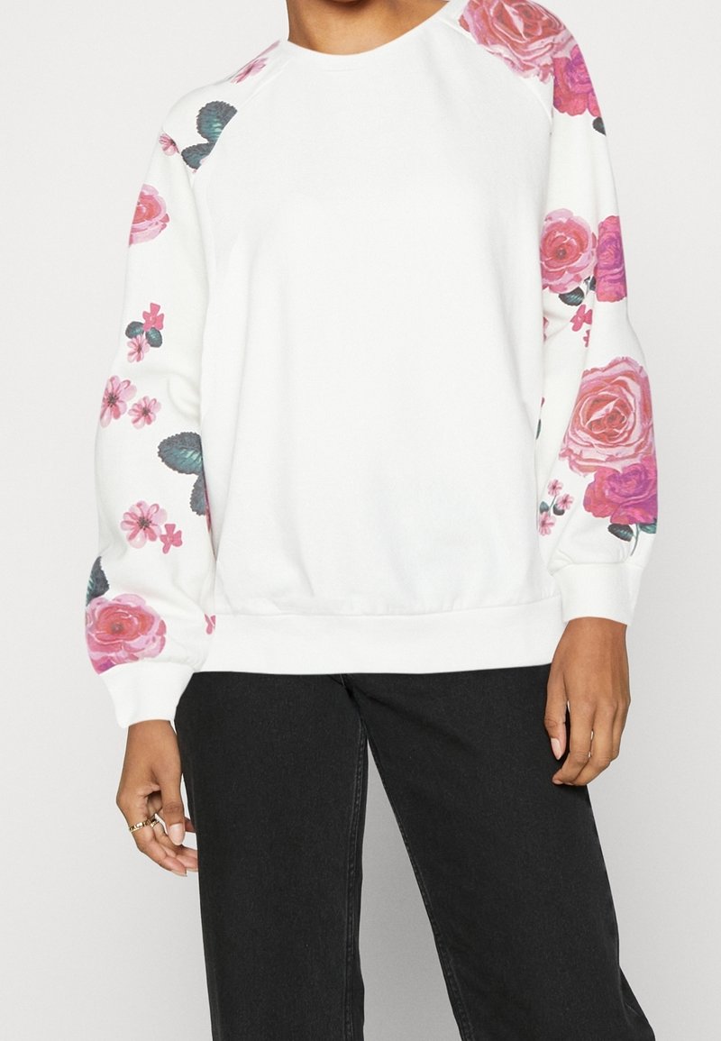 Felpa bianca con stampa floreale rosa e verde sulle maniche. Presenta una scollatura rotonda e polsini a coste. Tessuto morbido e confortevole.