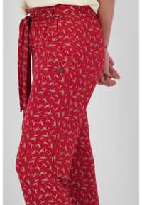 Rode, gestreepte broek van lichtgewicht stof, met een bloemendessin en een vastgebonden tailleband. Inclusief een kleine hartvormige accent.
