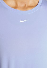 Helllila Nike Sportshirt mit glatter Textur, rundem Halsausschnitt und einem weißen Swoosh-Logo auf der Brust.