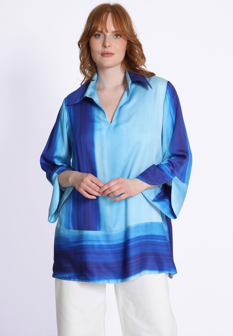 Blouse rayée bleu et bleu clair avec un col, des manches cloche trois-quarts et une coupe décontractée. Texture lisse semblable à de la soie.