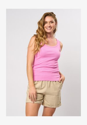 Rozā ribota topa bez piedurknēm ar apaļu kakla izgriezumu un mazu logotipu, apvienots ar bežām šortiem ar elastīgu jostasvietu un sānu kabatām.