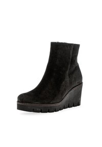 Stivale alla caviglia in suede nero con tacco a zeppa, punta arrotondata, cuciture a contrasto e suola piatta robusta. Texture liscia con design elegante.