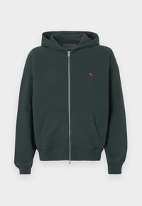 Haut à capuche zippé vert foncé en coton avec une poche kangourou, des poignets côtelés et un petit logo de moose brodé sur la poitrine.