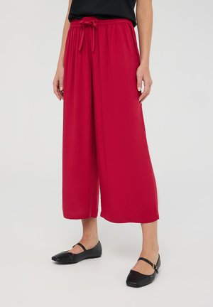 Pantaloni ampi rossi con vita regolabile, realizzati in tessuto leggero, caratterizzati da una texture liscia e una silhouette rilassata.