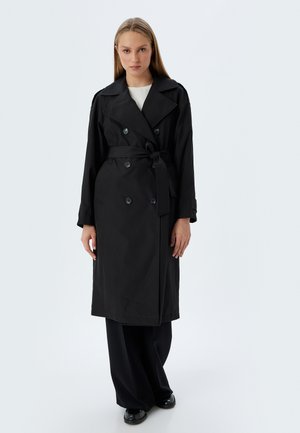 Cappotto trench nero con design doppiopetto, grandi bottoni e vita con cintura. Realizzato in tessuto liscio, presenta ampi revers e maniche lunghe.