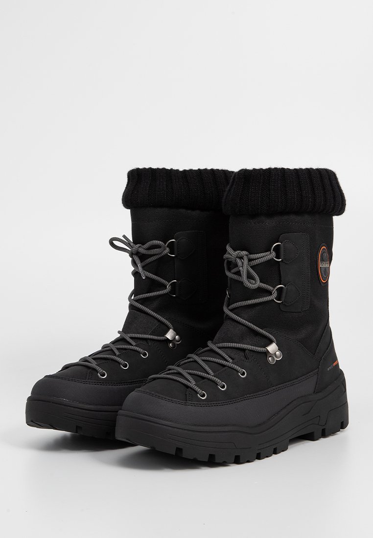 Zwarte geïsoleerde winterlaarzen met dikke rubberen zolen, vetersluiting aan de voorkant en omgeslagen gebreide toppen, ontworpen voor koud weer.