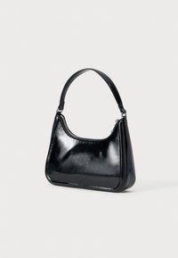 Čierna kožená taška na rameno s lesklým povrchom, zakriveným tvarom, jedným popruhom a zipsom na vrchu. Má elegantný siluet a prešité okraje.