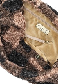 Bruine, zwarte en beige textuur van de binnenkant van de tas met gekruld stof. Bevat een ritsvak en een clip om spullen te beveiligen. Gemaakt van zacht materiaal.