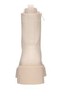 Stivaletto beige con finitura in pelle liscia, suola in piattaforma spessa e cerniera sul retro. Presenta un design minimalista e dettagli di cucitura discreti.