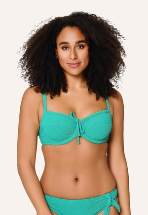 Haut de bikini en teal texturé avec armatures, bretelles ajustables et un détail de nouage sur le devant. Présente un petit accent en argent près du nœud.