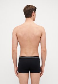 Schwarze Boxershorts mit einer engen Passform. Der Bund verfügt über zwei kontrastierende horizontale Streifen. Der Stoff wirkt glatt und elastisch.
