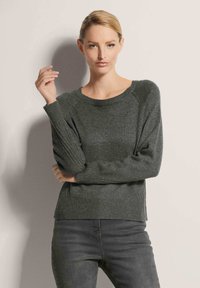 Dunkelgrüner gestrickter Pullover mit rundem Ausschnitt, gerippten Bündchen und lockerer Passform. Verfügt über eine weiche Textur und seitliche Schlitze für mehr Bewegungsfreiheit.