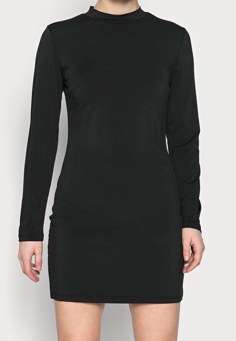 Mustavilla pitkähihaisella mekolla on sileä kangas, korkealle ulottuva kaulus ja tiukka siluetti, joka päättyy polven ylle.