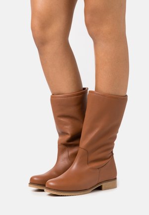 Bottes hautes jusqu'aux genoux en cuir marron avec une texture douce, bout arrondi, coutures latérales décoratives et talon bas.