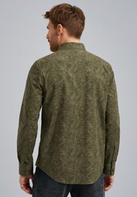Chemise à manches longues vert olive en tissu texturé, avec un col classique, des poignets à boutons et un ourlet légèrement arrondi.