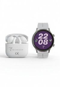 Auricolari wireless in custodia bianca accanto a uno smartwatch rotondo con cornice grigia, quadrante viola e grande display digitale bianco.