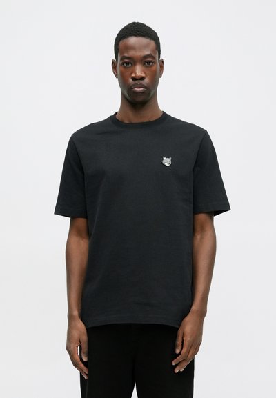 Tricou negru din bumbac, cu mâneci scurte, guler rotund și un mic patch brodat cu un lup pe piept. Design simplu și casual.