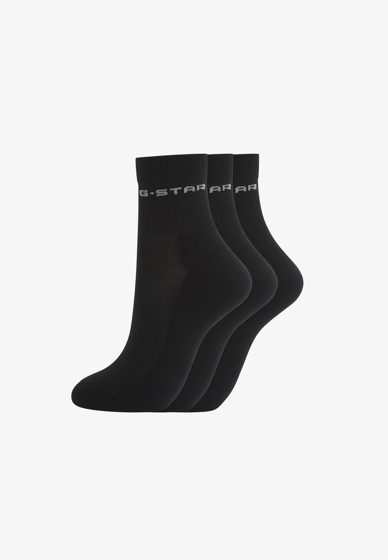 Trois paires de socquettes noires avec bord-côtes et logo texte gris clair sur chaque bord.