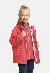 Giacca impermeabile rossa con cappuccio, polsini elasticizzati e accenti grigi. Presenta una chiusura con zip sul davanti e tasche laterali, design a strati.
