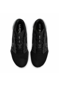 Scarpe sportive nere con tomaia in rete, design strutturato, lacci piatti e suola testurizzata con branding visibile sulle solette.