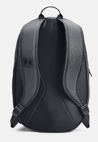 Zaino nero con spallacci imbottiti e tessuto strutturato con logo; interno spazioso con tasca laterale con zip per riporre oggetti.