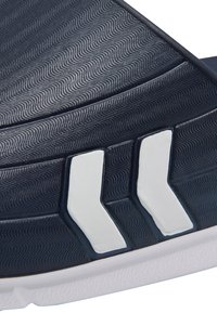 Marineblå idrottssandal med ett strukturerat mönster, vita accentlinjer och en gummisul för grepp och hållbarhet.