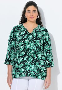 Blusa verde e bianca a motivo su sfondo nero, con scollatura a V e maniche tre quarti, realizzata in un tessuto leggero.