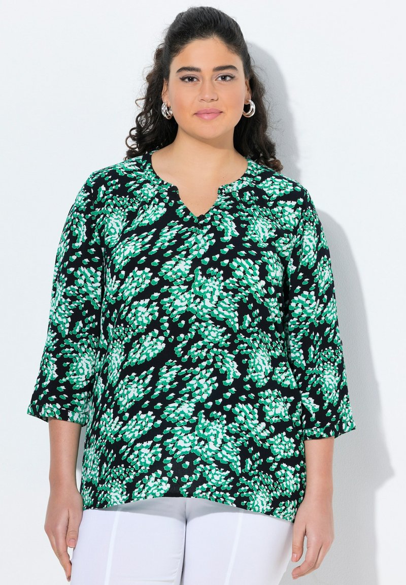 Blusa verde e bianca a motivo su sfondo nero, con scollatura a V e maniche tre quarti, realizzata in un tessuto leggero.