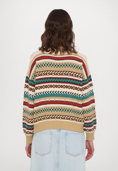 Maglione a maglia con una base beige e righe multicolori in rosso, verde, marrone e crema, caratterizzato da una vestibilità ampia e polsini a coste.