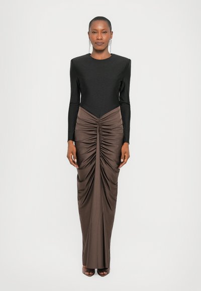 Haut noir à manches longues avec un décolleté en V plongeant, associé à une jupe longue à fronces de couleur marron, mettant en valeur une texture lisse et un design élégant.