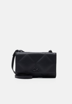 Borsa a tracolla in pelle nera con un design trapuntato, logo "CK" impresso e una tracolla rimovibile. Texture liscia con hardware minimale.